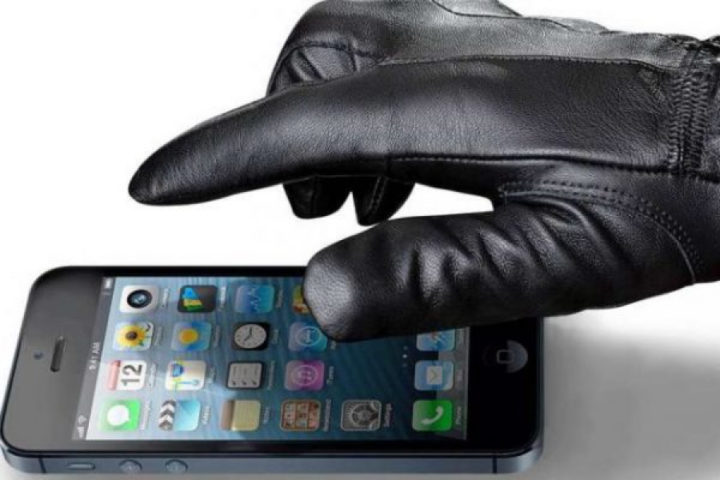 Рука в перчатке берет смартфон