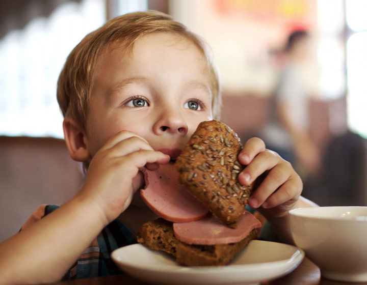 Ребенок ест колбасу